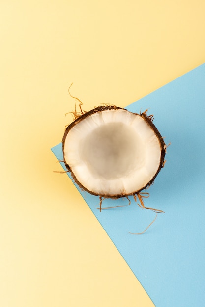 Uma vista superior cocos cortados maduro leitoso fresco isolado na cor creme-gelado-azul