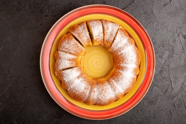 Foto grátis uma vista superior doce redondo bolo com açúcar em pó fatiado doce delicioso bolo isolado dentro da placa e fundo cinza biscoito de açúcar