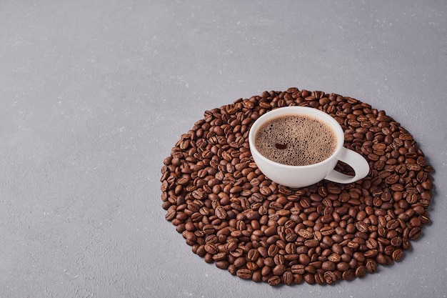 Uma xícara de café com grãos de arábica.