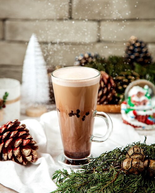 Uma xícara de café com leite ao lado de decorações de Natal