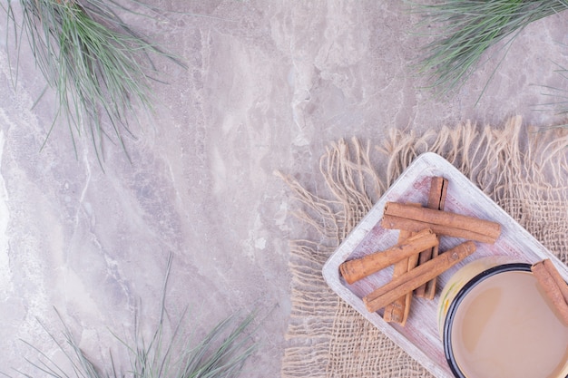 Foto grátis uma xícara de café com sabor de canela em uma placa de madeira