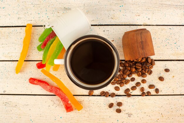 Uma xícara de café com vista de cima com sementes de café frescas e marmelada colorida