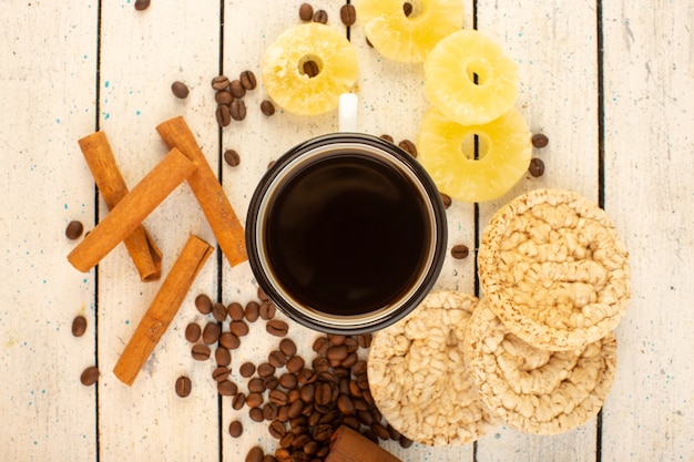 Uma xícara de café com vista de cima e biscoitos de canela com sementes de café fresco