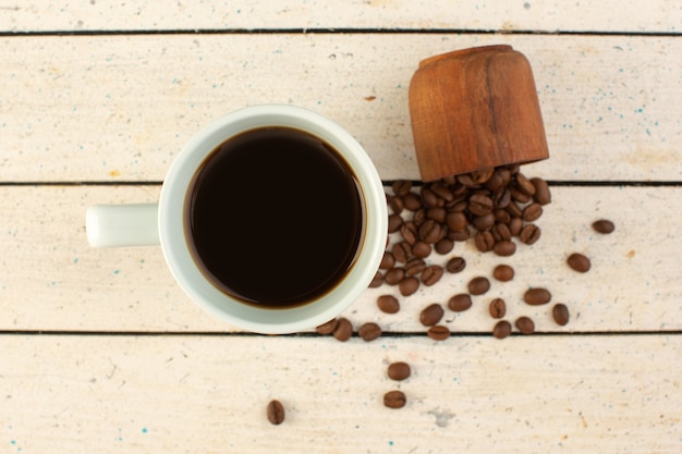 Uma xícara de café com vista de cima em uma xícara branca com sementes frescas de café marrom