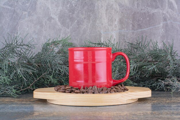 Uma xícara de café delicioso com grãos de café na placa de madeira