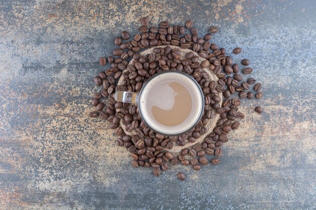 Uma xícara de café delicioso com grãos de café no fundo de mármore. Foto de alta qualidade