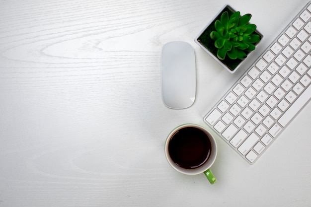 Uma xícara de café e teclado sem fio com o mouse
