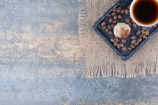 Uma xícara de café escuro com biscoito no quadro escuro. Foto de alta qualidade