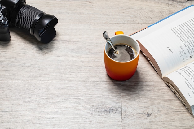 Foto grátis uma xícara de café expresso com um bom livro e uma câmera fotográfica ao redor