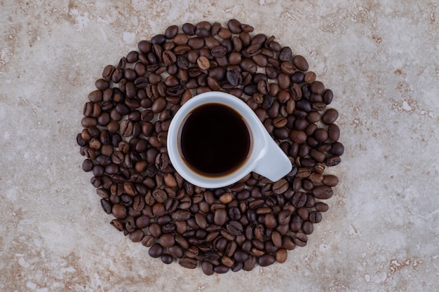 Uma xícara de café rodeada de grãos de café