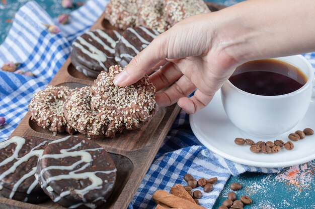 Uma xícara de café servida com biscoitos de chocolate.