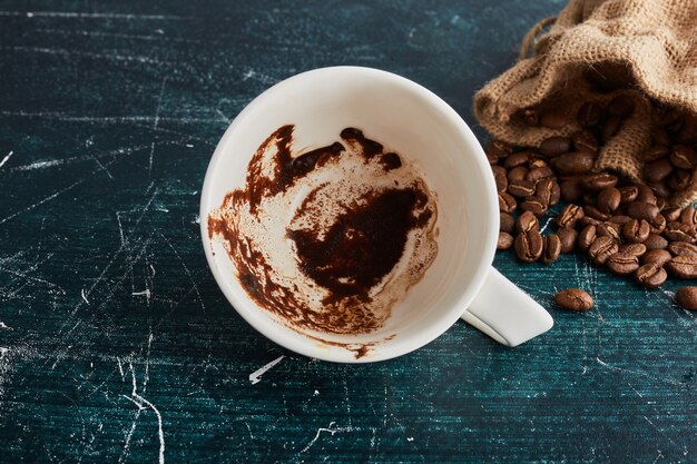 Uma xícara de café suja com feijão.