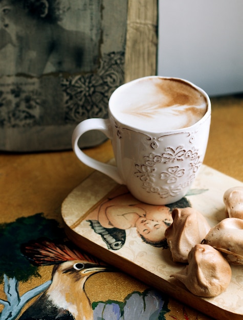 Uma xícara de cappuccino com biscoitos