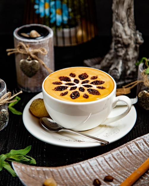 Uma xícara de cappuccino com decoração floral de cacau.