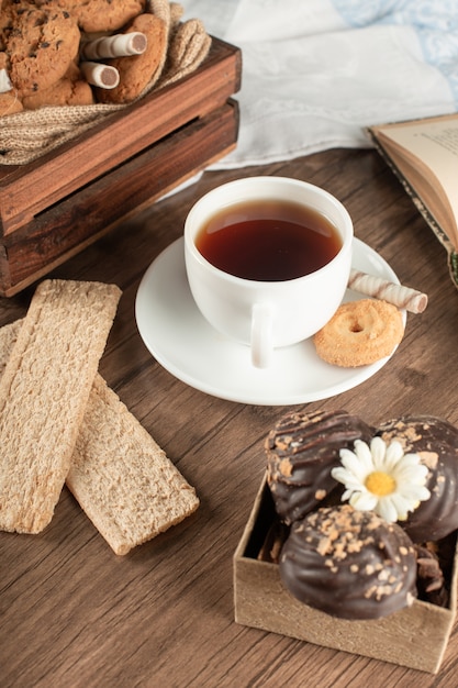 Uma xícara de chá com alguns biscoitos crocantes.