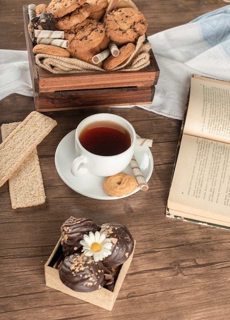 Uma xícara de chá com biscoitos de aveia e biscoitos.