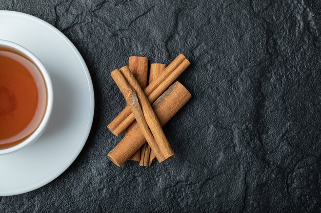 Foto grátis uma xícara de chá com canela em pau e infusão.