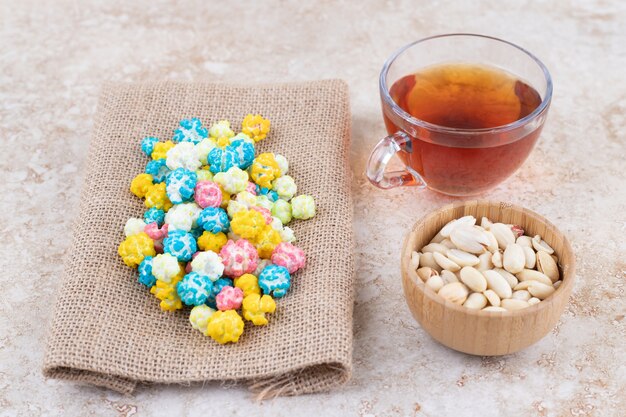 Foto grátis uma xícara de chá quente com doces coloridos