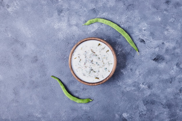 Uma xícara de sopa de iogurte com feijão verde.