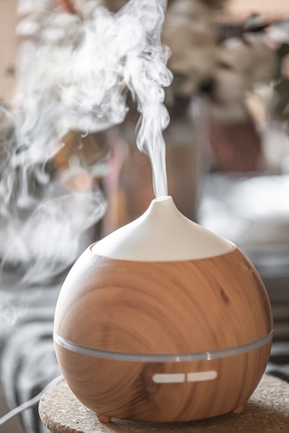 Foto grátis umidificador difusor de aroma de óleo essencial que difunde artigos de água no ar.