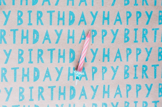 Única vela listrada em papel de feliz aniversário