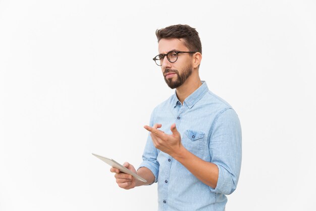 Usuário de tablet pensativo olhando e apontando o dedo para longe