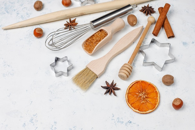 Utensílios de cozimento de cozinha com temperos para biscoitos e cortadores de biscoito na superfície da luz