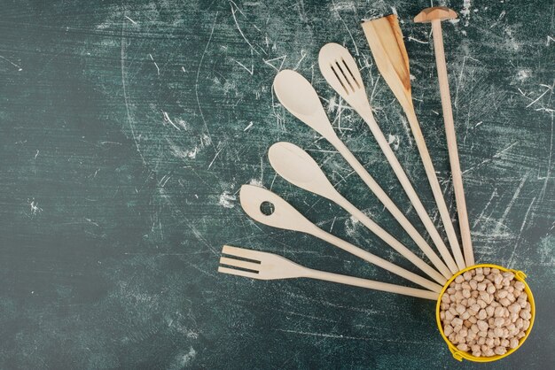 Utensílios de cozinha com balde amarelo de nozes em fundo de mármore. Foto de alta qualidade