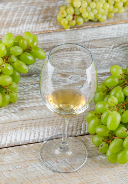 Foto grátis uvas doces com close-up de bebida em um fundo de madeira