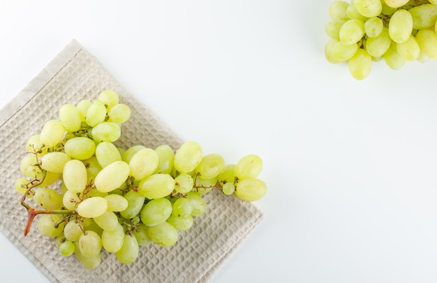 Foto grátis uvas verdes em branco e toalha de cozinha,