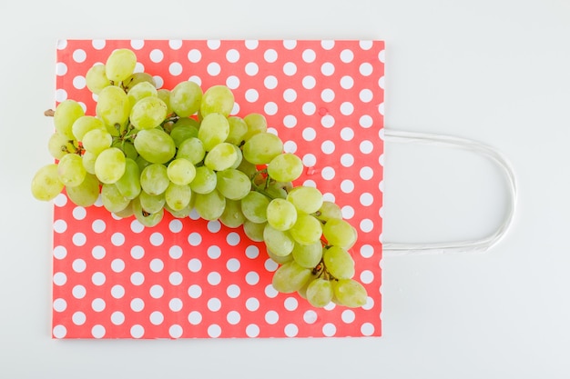 Uvas verdes em saco branco e de papel.