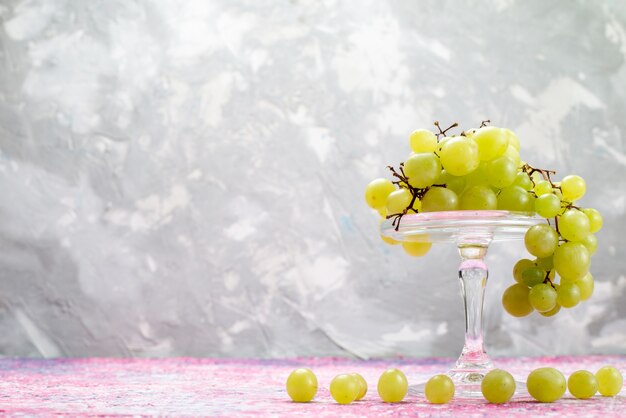 uvas verdes frescas inteiras azedas e frutas deliciosas na luz