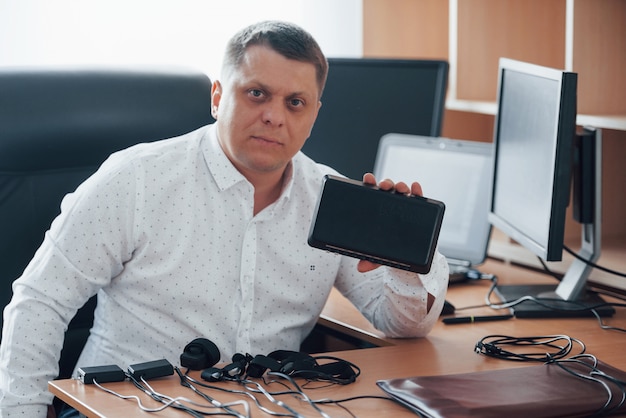 Foto grátis vamos expor sua desonestidade com isso. o examinador do polígrafo trabalha no escritório com seu equipamento detector de mentiras