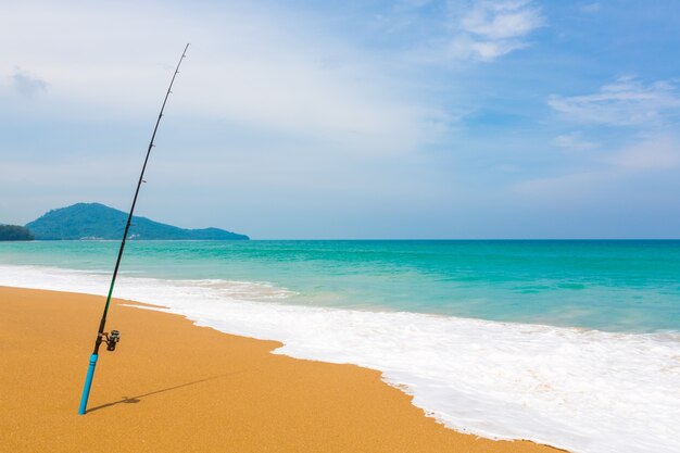 Vara de pesca na areia da praia tropical