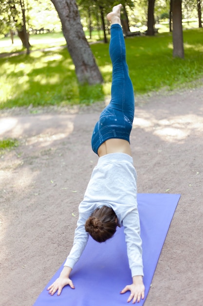 Foto grátis variação de adho mukha svanasana no parque