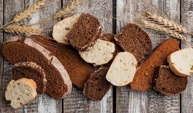 Várias fatias de pão na prancha de madeira fundo plano leigos