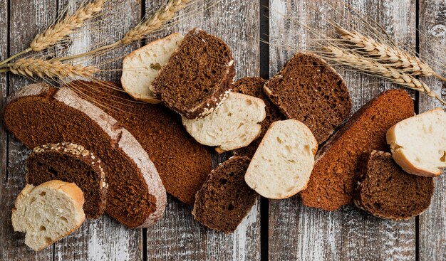 Várias fatias de pão na prancha de madeira fundo plano leigos