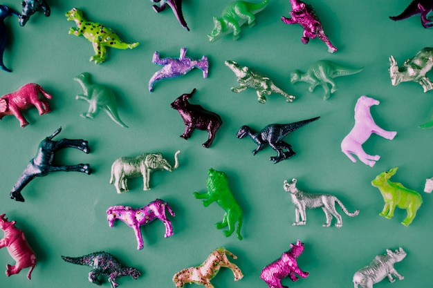 Várias figuras de brinquedos de animais em um fundo colorido