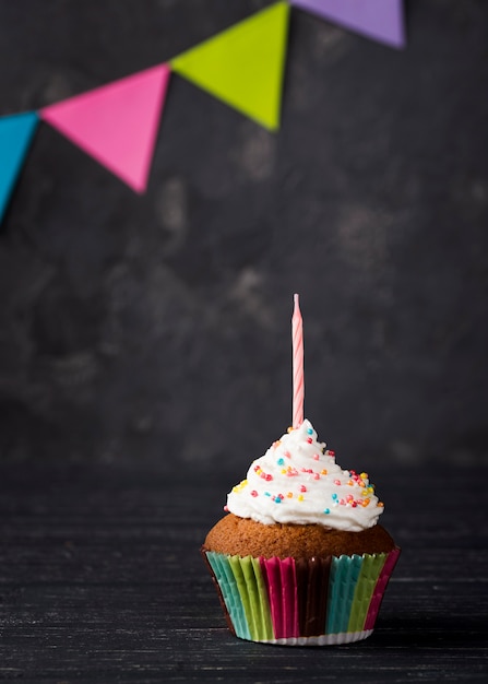 Variedade com muffin e vela em fundo de madeira