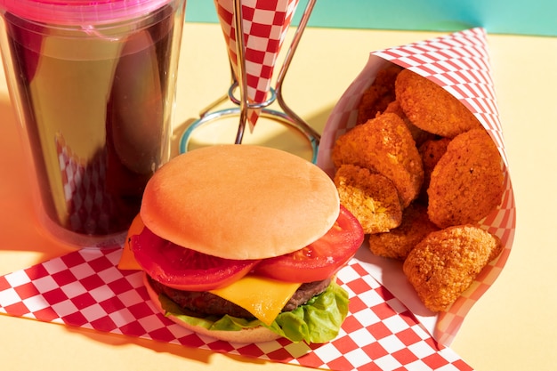 Foto grátis variedade de alto ângulo com nuggets de frango e copo de suco