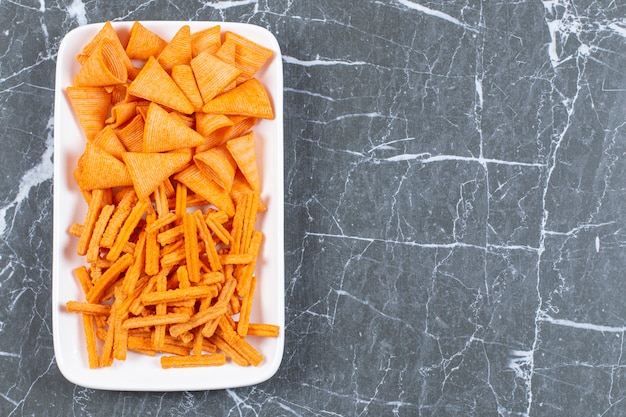 Foto grátis variedade de batatas fritas com especiarias na chapa branca.