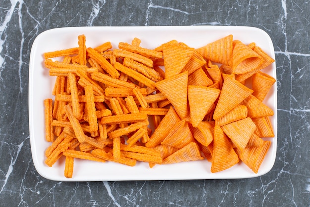 Foto grátis variedade de batatas fritas com especiarias na chapa branca.