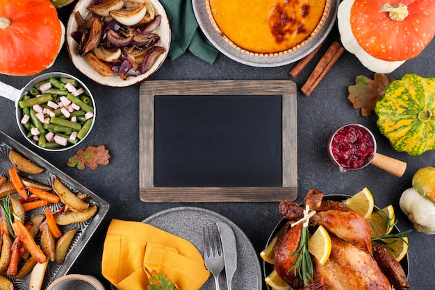 Foto grátis variedade de delicioso jantar do dia de ação de graças com quadro-negro