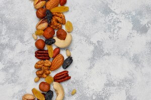 Foto grátis variedade de nozes em pratos de cerâmica. caju, avelãs, nozes, pistache, nozes, pinhões, amendoim, passas. vista superior