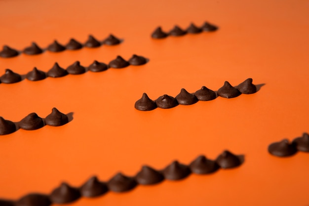 Foto grátis variedade de pedaços de chocolate saboroso com fundo laranja