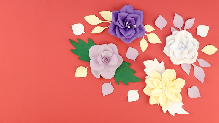Foto grátis variedade de vista superior com flores de papel e fundo vermelho