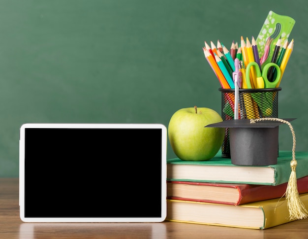 Foto grátis variedade do dia da educação em uma mesa com um tablet