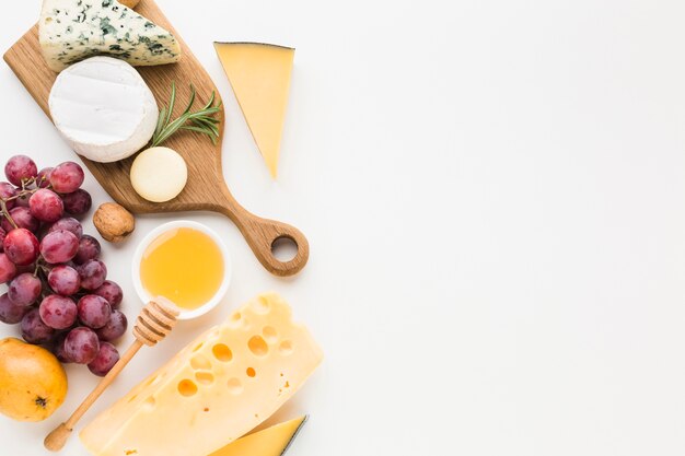 Variedade gourmet de vista superior de queijo na tábua de madeira e uvas com espaço de cópia
