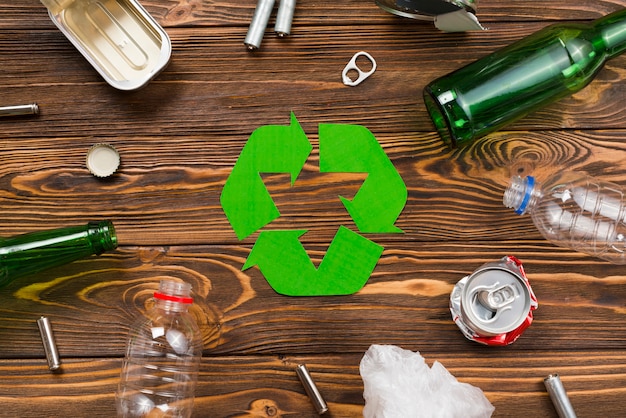 Vário lixo reutilizável em torno do símbolo de reciclagem