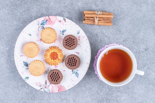 Foto grátis vários biscoitos no prato com uma xícara de chá quente